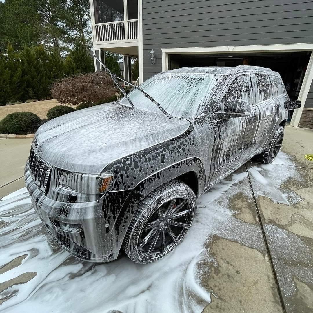 Jeep Grand Cherokee covered in thick foam during a mobile hand wash